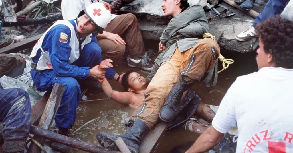Socorristas intentan rescatar a Omaira Sánchez, atrapada tras la avalancha del volcán Ruiz en 1985.
